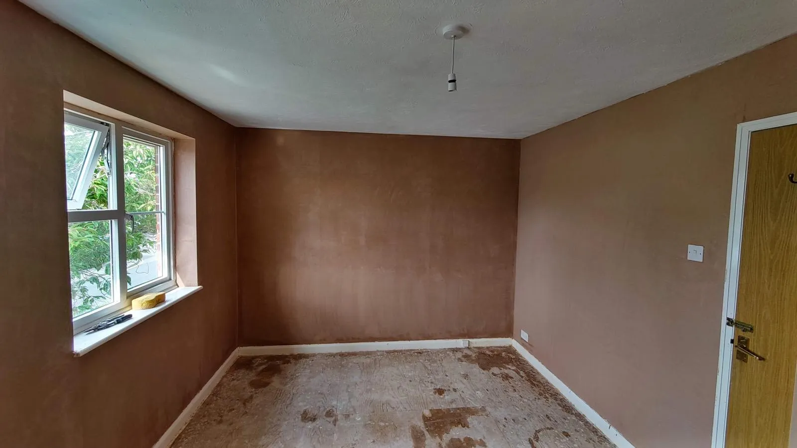 Freshly skimmed bedroom walls drying beside a window by BJL Plastering & Rendering